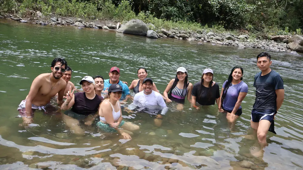 Colaboradores en el río durante una jornada de integración