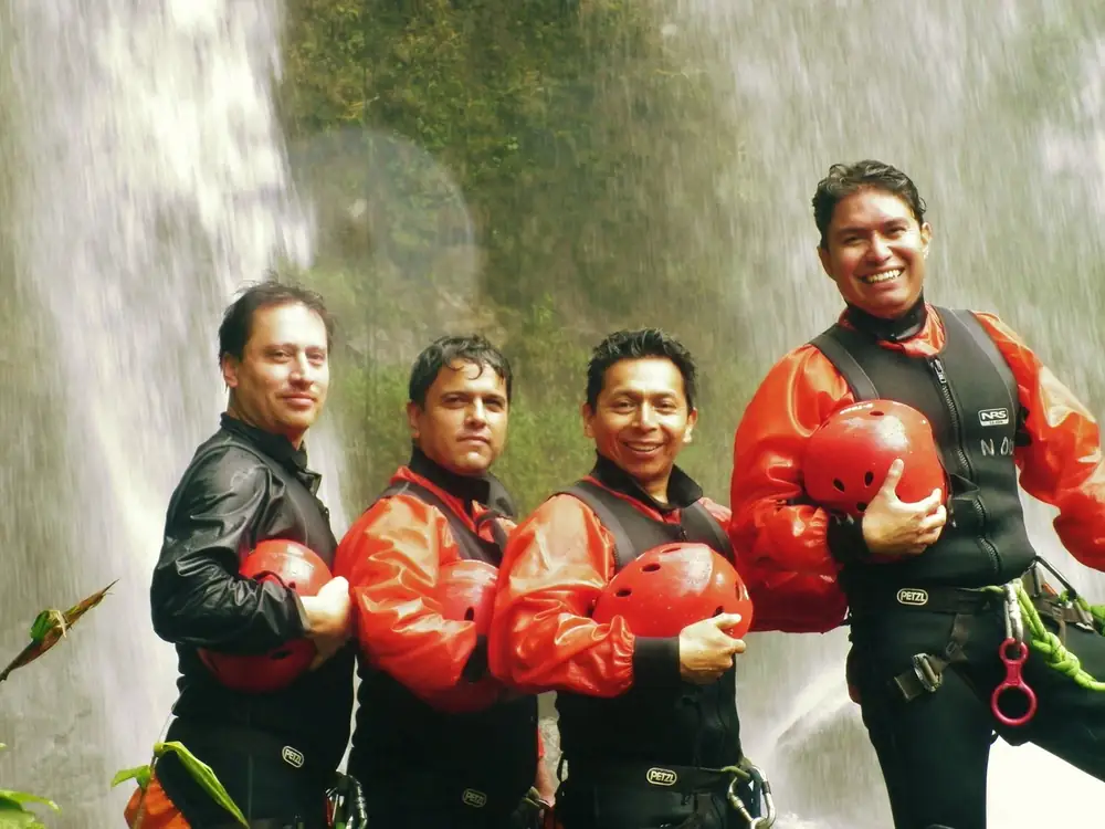 Equipo junto a una cascada en una actividad de aventura